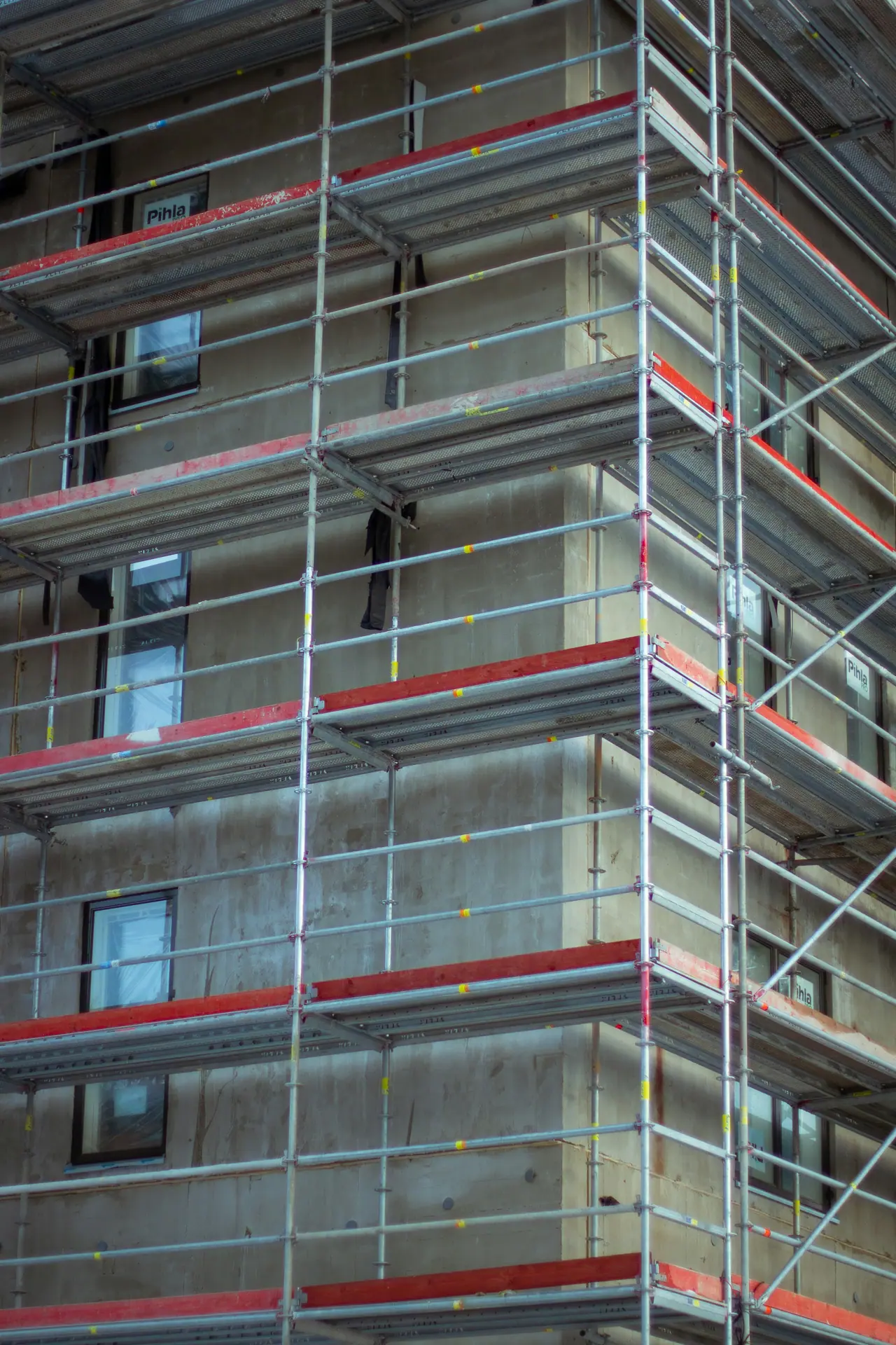 Façade d’immeuble en construction, couverte d’échafaudages. Réceptions de travaux, réserves, malfaçons : chaque étape du chantier est tracée dans un dossier de preuve scellé.
